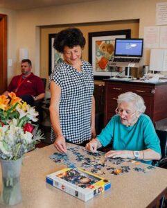 Women putting a puzzle together in JSL's Memory Care Residence